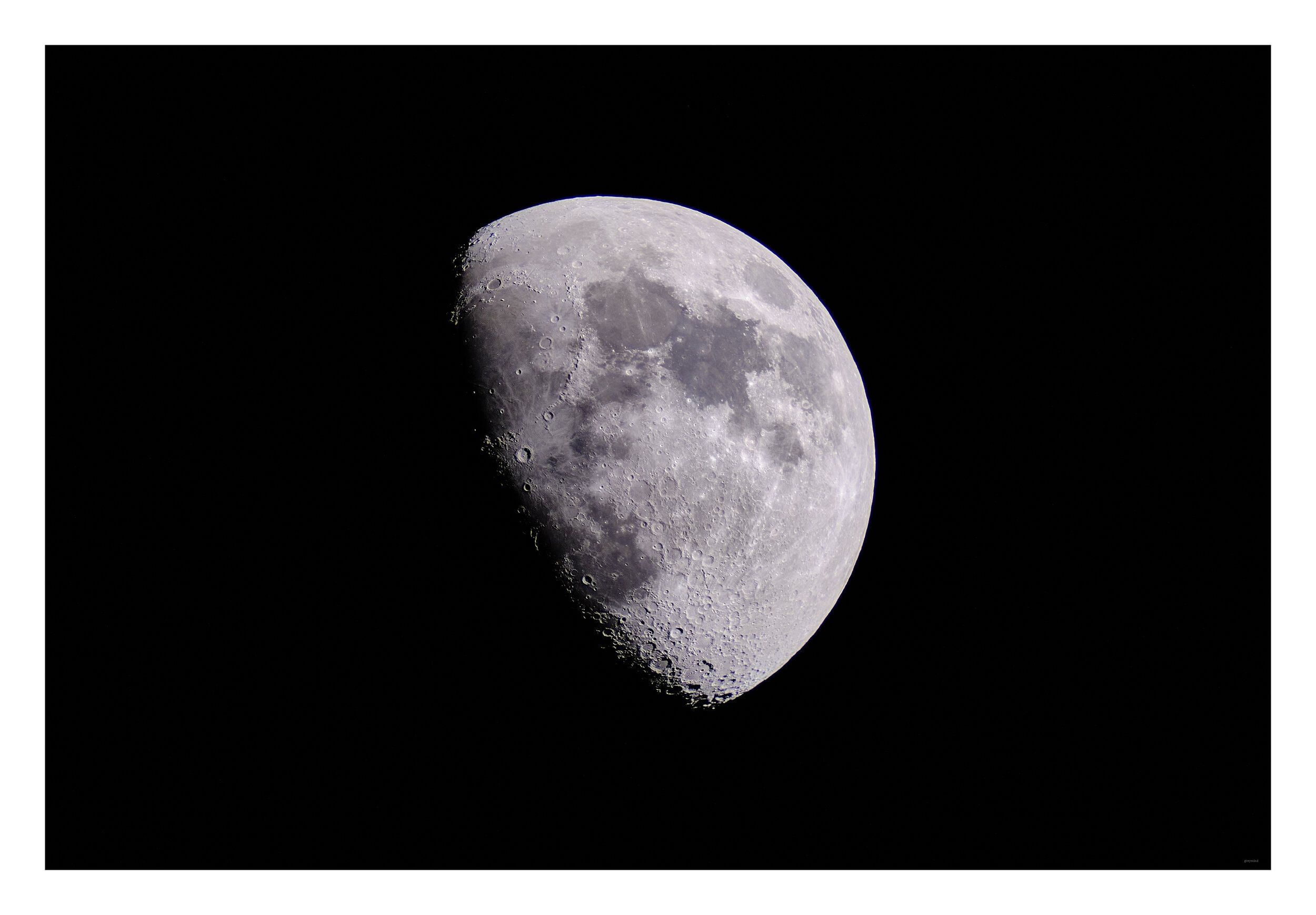A gibbous moon, its craters sharp against a black sky.